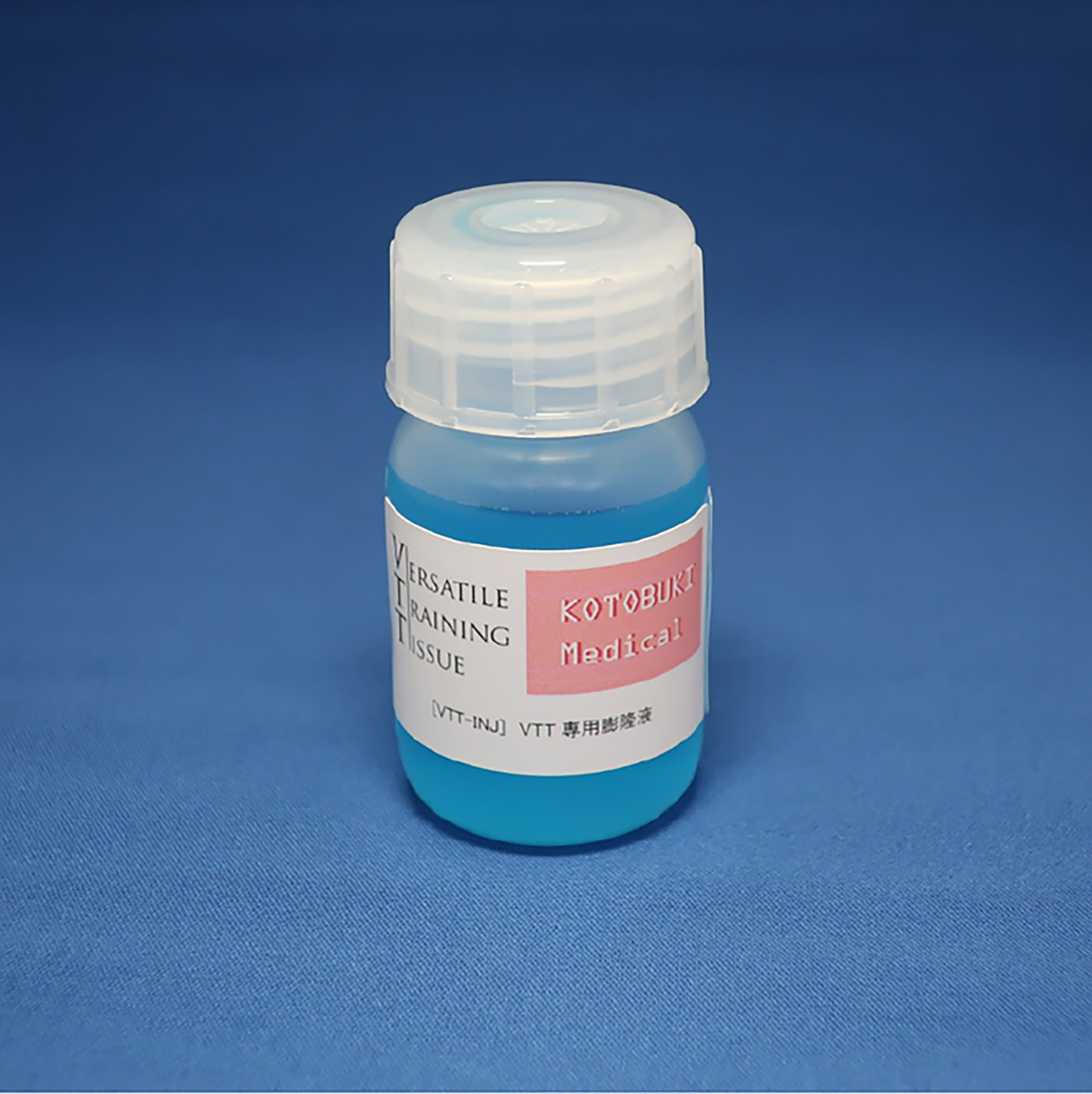 A bottle of lesion-raising VTT Injection Solution against a blue background. The contents of the bottle are also blue.