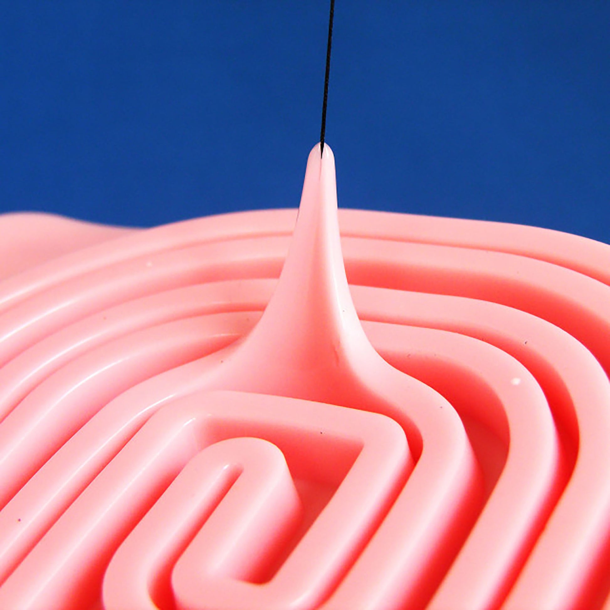 Demonstration of the Soft Training Pad Swirl's flexibility and tear resistance. The soft silicon stretches liberally when pulled up using inserted thread.