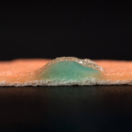 A cutaway side view of the VTT Mucosa Model, which has been injected with lesion-raising VTT Injection Solution. The raised lesion presents as a pocket of blue gel beneath the mucosal layer.